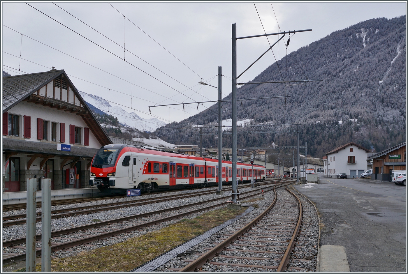
Im Wallis, in einem versteckten Seitental, schon nahe der Grenze zu Italien, habe ich einen neuen FLIRT gefunden, der auf den Name EVO h�rt. Es wird wohl einer der ersten Z�ge dieser Baureihe im Planverkehr sein: in Orsi�res wartet der TMR Region Alpes RABe 533 601 (UIC Nummer RABe 94 85 0 533 701-4 CH-RA) mit dem Wappen  Commune de St L�onard  und dem dazu passenden Namen  La Souterraine  als R82 26325 auf die Abfahrt nach Sembrancher. 24. Januar 2026