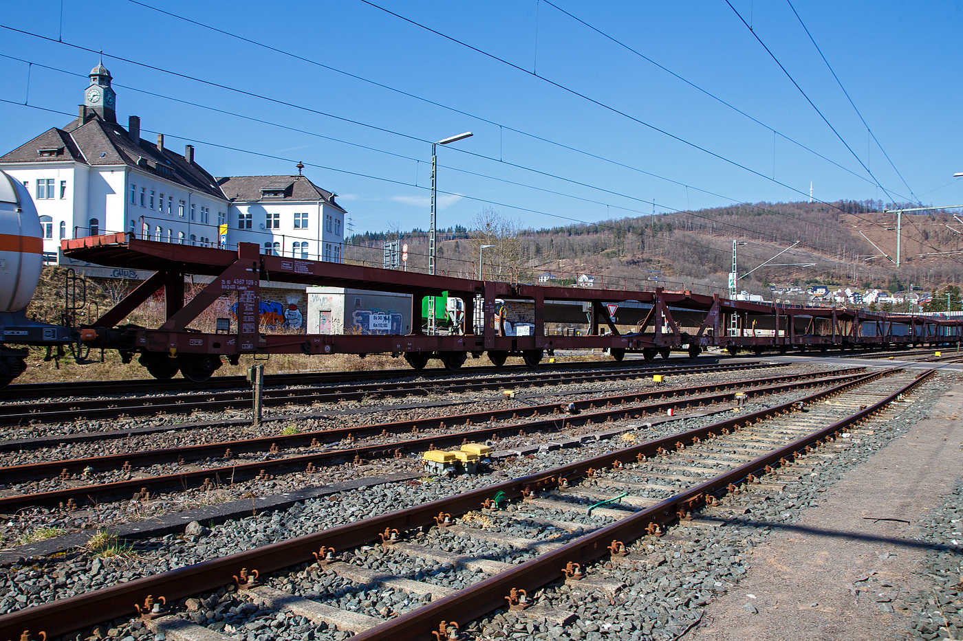 Leere Doppelstock-Autotransportwagen-Einheit 25 80 4367 109-2 D-ATG und weitere, der Gatttung Laaeks 553, der DB Schenker Rail Automotive GmbH (ex DB Schenker ATG) am 24.03.2021 im Zugverband bei der Durchfahrt in Niederschelden.

Die zuverlässigen und robusten Wagen dieser Bauarten wurden für den internationalen Transport von PKW entwickelt.

Zur Be- und Entladung der oberen Ladeebene an Kopframpen können die Wagenenden aus der Transportstellung in die sogenannte Rampenstellung abgesenkt beziehungsweise angehoben werden. Des Weiteren können die Wagenenden der oberen Ladeebene in die Beladestellung angehoben werden. Hierdurch wird die maximale Durchfahrtshöhe für die Be- und Entladung der Fahrzeuge auf der unteren Ladeebene realisiert.

TECHNISCHE DATEN:
Gattung: Laaeks (Bauart 553)
Spurweite: 1.435 mm
Anzahl der Achsen: 4
Länge über Puffer : 27.000 mm
Ladelänge : 26.100 mm (unten) / 26.500 mm (oben)
Ladebreite : 3.000 mm (unten) / 2.910 mm (oben)
Wagenhöhe: 3.400 mm
Höchstgeschwindigkeit: 100 km/h (120 km/h leer)
Eigengewicht: ca. 26.700 kg
Nutzlast: 18,5 t (unten max. 12 t / oben max. 10 t)
Abstand der äußeren Radsätze: 22.300 mm (9.000 / 4.300 / 9.000 mm)
Kleinster befahrb. Gleisbogenhalbmesser: 80 m
Verwendungsfähigkeit: RIV