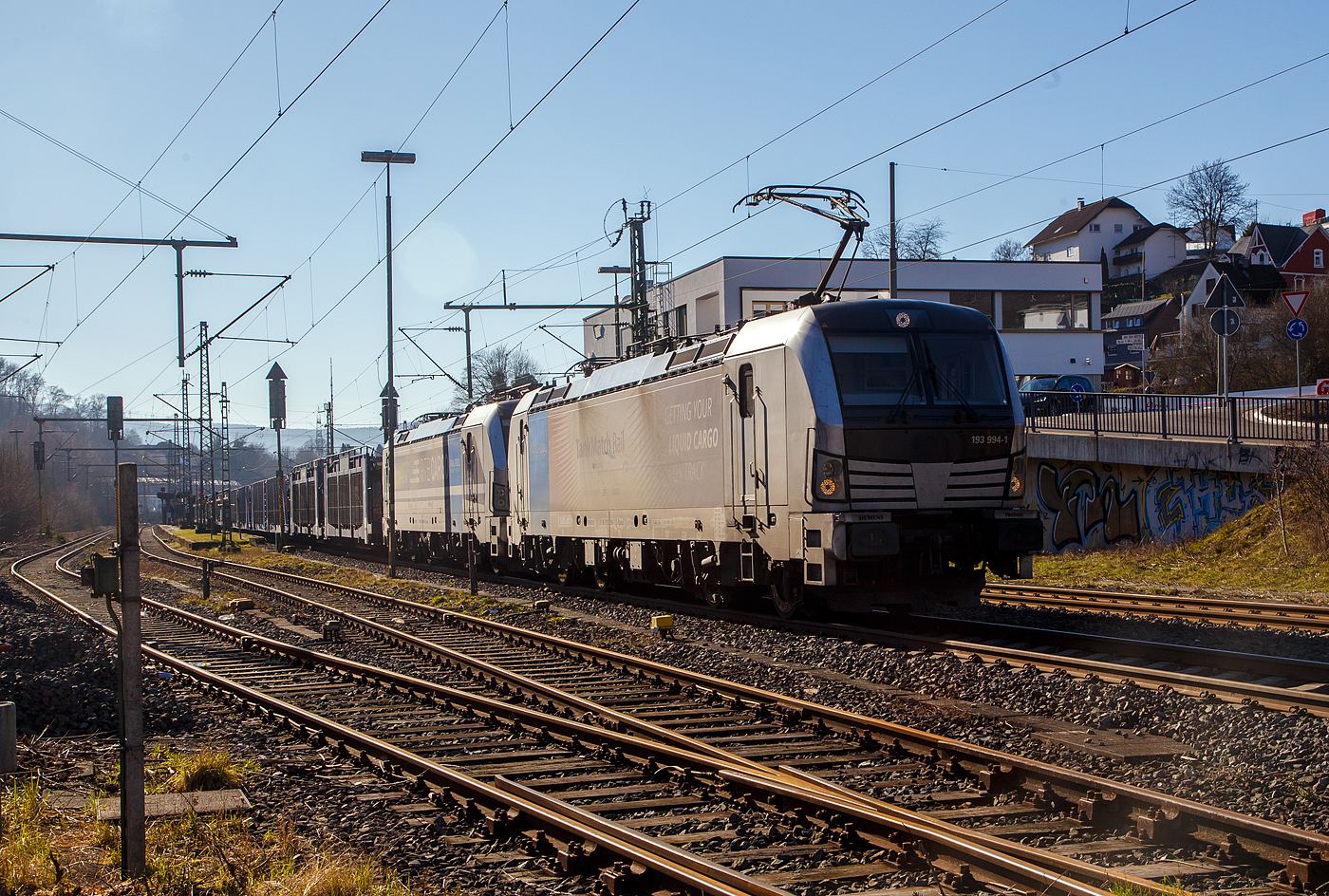 Leider hatte sich der Stand der Sonne schon stark gedreht...
Die beiden an die RTB CARGO GmbH vermietete SIEMENS Vectron AC, vorne die 193 994-1 (91 80 6193 994-1 D-Rpool) und dahinter die kalte (somit keine Doppeltraktion) 193 999-0 „Győr“ (91 80 6193 999-0 D-Rpool), beide der Railpool (München), fahren am 14.02.2023, mit einem leeren Touax-Autotransportzug (Wagen der Gattung Laaers), über die Siegstrecke (KBS 460) durch Niederschelden in Richtung Siegen.

Beide Vectron AC wurden 2019 von Siemens Mobilitiy in München-Allach gebaut, die 193 994 unter der Fabriknummer 22682 und die 193 999 unter der Fabriknummer 22698. Diese Vectron Lokomotiven sind als AC – Lokomotive (Wechselstrom-Variante) mit 6.400 kW konzipiert und zugelassen für Deutschland, Österreich und Ungarn (D/A/H), eine Zulassung für Rumänien (RO) wurde noch nicht erlangt, RO ist durchgestrichen. Die Loks haben eine Höchstgeschwindigkeit von 200 km/h.
