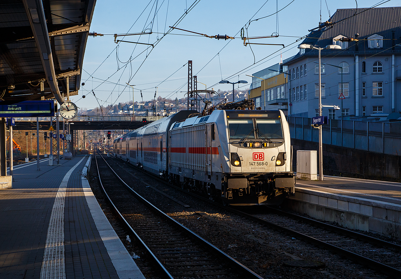 Mit ca. 15 Minuten Verspätung erreicht die 147 568-0 (91 80 6147 568-5 D-DB - IC 4895) der DB Fernverkehr AG, mit dem IC 2322 (Friedberg/Hessen - Siegen - Hamm - Münster - Norddeich Mole), am 15.12.2022 den Hauptbahnhof Siegen. Wegen Bauarbeiten fahren die IC2 nicht ab/bis Frankfurt a. M. Hbf sondern erst ab/bis Friedberg/Hessen. 

Die TRAXX P160 AC3 wurde 2019 von Bombardier in Kassel unter der Fabriknummer 35611 gebaut und an die DB Fernverkehr AG geliefert. Sie hat die Zulassungen für Deutschland. Für die Schweiz ist/war die Zulassung auch vorgesehen, daher hat sie auch vier Stromabnehmer (je 2 mit breiter Wippe und schmaler Wippe), doch wurde noch keine und wird wohl auch keine Zulassung für die Schweiz vom Hersteller erlangt.
