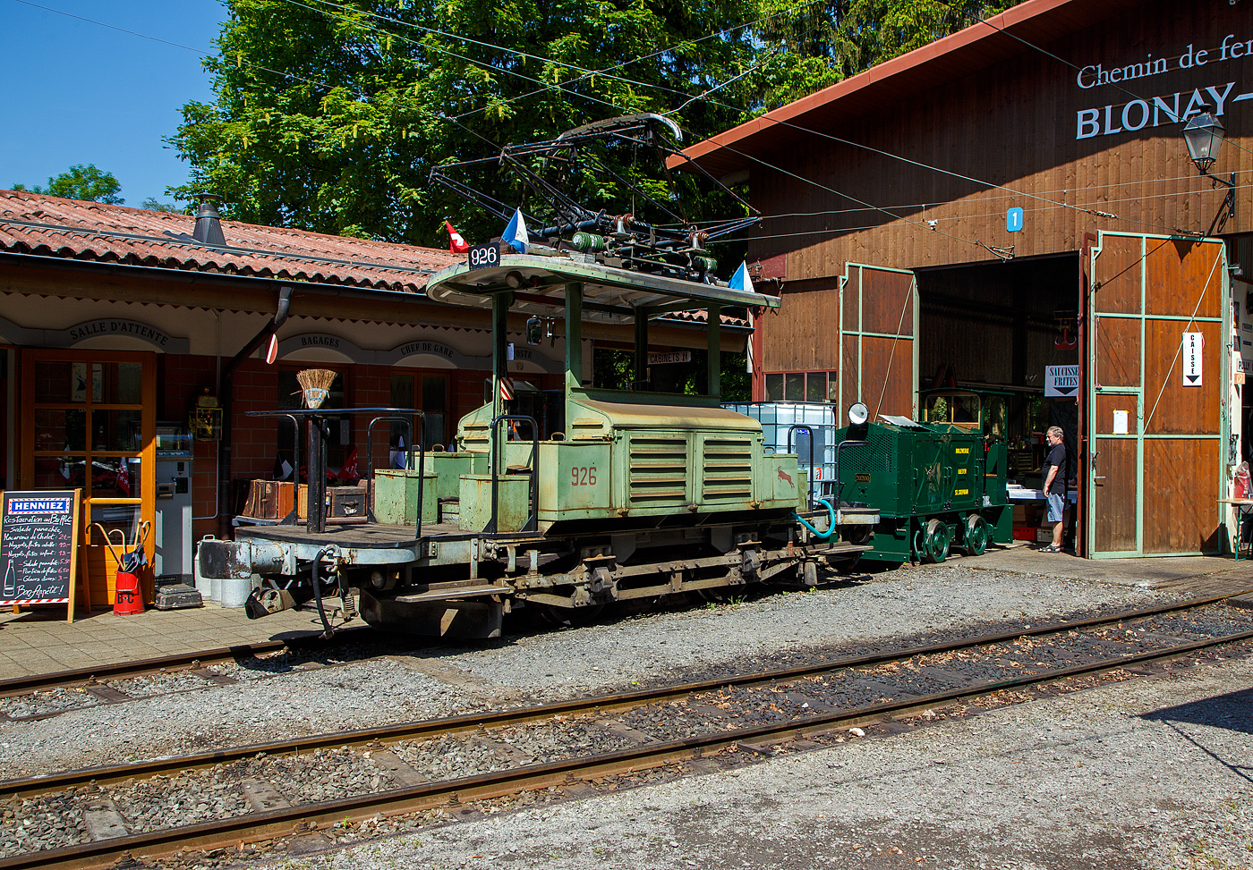 Mit einem 1m³-Wassertank und einer Motorspritze ausgestatte, als Feuerlöschreserve...
Der Te 2/2 926 der Museumsbahn Blonay-Chamby, ex VBZ (Verkehrsbetriebe Zürich) Schienentraktor Xe 2/2 – 1926, ex Xe 2/2 – 926, ex StStZ Xe 2/2 – 926, der Museumsbahn Blonay-Chamby am 27.05.2023 im Museum Chaulin. Dahinter der kleine ex MOB Schienentraktor Tm 2/2 Nr. 1, ex Holzwerk Rieder, der Museumsbahn.

Der Te 2/2 Schienentraktor wurde 1935 von der damaligen Städtische Straßenbahn Zürich (StStZ) selbst gebaut, der elektrische Teil ist von der Maschinenfabrik Oerlikon (MFO). Gebaut worden sind, zwische1930 und 1935, drei dieser Rangiermaschinen Nr. 924-926 (ab 1946 in Nr. 1924 bis1926), dabei wurden Untergestell, Elektrik und Motoren von Ce 2/2 Triebwagen der Serie 57-84 (mit markantem Peckham-Untergestell) verwendet. 

Die drei Manövrierwagen von erhielten zur Erleichterung der Fahrtrichtungswechsel von Anfang an einen Pantografen statt des umständlichen Lyrabügels. Die Rangierer fügten in den Depots den Triebwagen für die Hauptverkehrszeit die Beiwagen zu. Die Führerstände waren längs eingebaut, mit freier Sicht auf die Kupplungen, so konnte man mit ihnen sozusagen millimetergenau anfahren. Ihr grüner Anstrich und das charakteristische Fahrverhalten trugen ihnen den Spitznamen „Laubfrosch“ ein.

Speziell für Zürich war die große Flotte von Rangierfahrzeugen. Diese hatten die Aufgabe, für die Stoßzeit Verstärkungswagen beizustellen und danach wieder von den Tramzügen abzuziehen. Dazu gehörten auch Fahrten zwischen dem zugeteilten Depot und den Bereitstellungsgleisen an Wendeschleifen. Ende der 1960ziger Jahre wurde, durch die große Zahl angeschafften Mirage-Gelenkzüge, die Flotte von 24 Stück Rangierfahrzeugen überflüssig. Das Beistellen und Abziehen von Tramanhängern vor und nach der Stoßzeit war nun überflüssig. So war 1969 war ihre Zeit abgelaufen. Während die beiden Xe 2/2 1924 und 1025 Stück abgebrochen wurden, übergab die Stadt Zürich Xe 2/2 1926 an die eben im Aufbau begriffene Museumsbahn Blonay - Chamby BC. Dort leistete das gut unterhaltene und sehr bewegliche Triebfahrzeug wertvolle Dienste bei der Wiederinbetriebnahme der Strecke und beim Bau des Depots. Heute wird der „Laubfrosch“ mit seiner alten Zürcher Nummer 926 bestimmungsgemäß als Rangierfahrzeug auf dem Depotareal der BC benutzt. Hier kann der Laubfrosch seine Stärken ausspielen. Für den Einsatz auf der Museumsbahn musste Xe 2/2 926 die +GF+-Kupplung gegen eine herkömmliche Mittelpufferkupplung tauschen. Um den Betrieb unter der Spannung von 1000 V DB (MOB-GFM) zu ermöglichen, wurde ein zusätzlicher Widerstand montiert, die Straßenbahn Zürich fuhrt ja unter 700 V DC. Trotz der zusätzlichen Widerstände leistet er sehr gute Arbeitet bei der BC. Bei der Museumsbahn Blonay–Chamby tägt der Te 926 nicht den Spitznamen „Laubfrosch“ sondern „Le Bouc“ (Der Bock).

Hier wurde das Fahrzeug präventiv als Löschfahrzeug, für evtl. Bekämpfung von Böschungsbränden nach Funkenwurf durch die Dampflokomotive, vorgehalten. Gelegentlich rückt die BC Xe 2/2 926 mit dem Sprengwagen Xe 2/2 1, ex Straßenbahn Biel aus, der noch nicht wieder mit Fahrmotoren ausgerüstet ist.

TECHNISCHE DATEN:
Spurweite: 1.000 mm (Meterspur)
Gewicht: 9,3 t
Höchstgeschwindigkeit: 36 Km/h
Leistung: 2 x 44 kW = 88 kW (120 PS)
Triebraddurchmesser: 840 mm (neu)
Getriebeübersetzung: 1:4,277
Spannung: (ursprünglich) 700 V DC, bei der BC 1000 V DC

Quellen: BC, Drehscheibe
