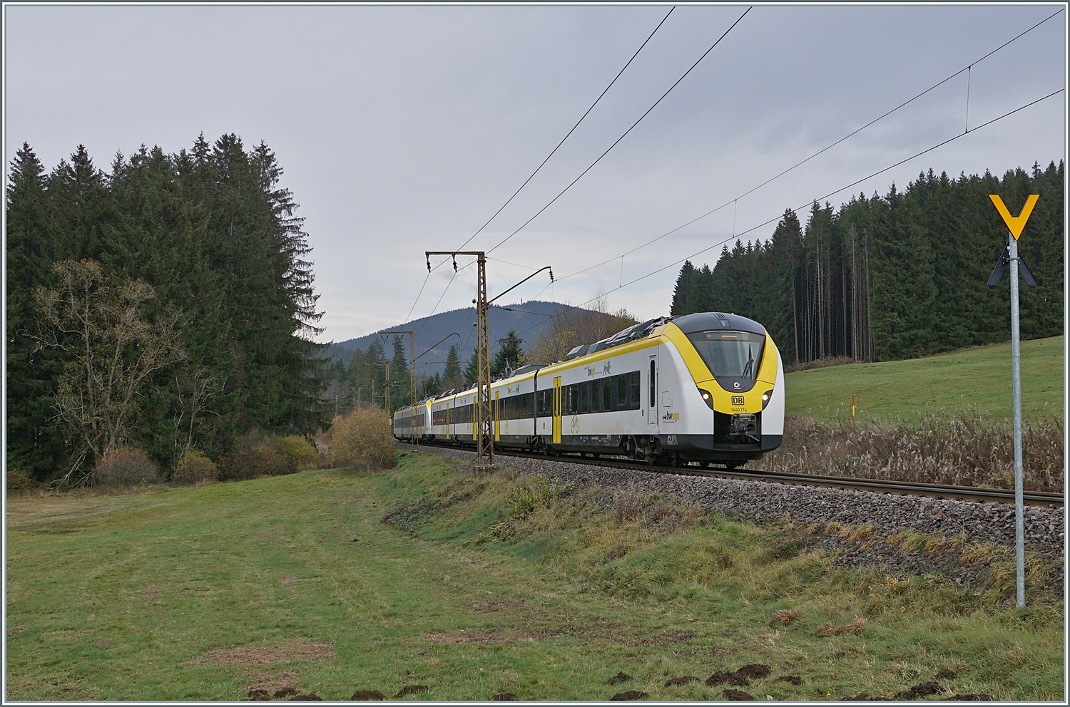 Nachdem der Zug auf dem vorangegangenen Bild etwas  versteckt  zu sehen war, hier an fast derselben Stelle zwischen Titisee und Hinterzarten die bedienen DB 1440 174 und 862 als S 1 9618 von Seebrugg nach Breisach.
Ebenfalls bemerkenswert der noch aus Anfangszeit der Elektrifizierung stammende Fahrleitungsmast, der ursprnglich mit 20000 Volt 50 Hertz gespiesenen Strecke. 

14. November 2022