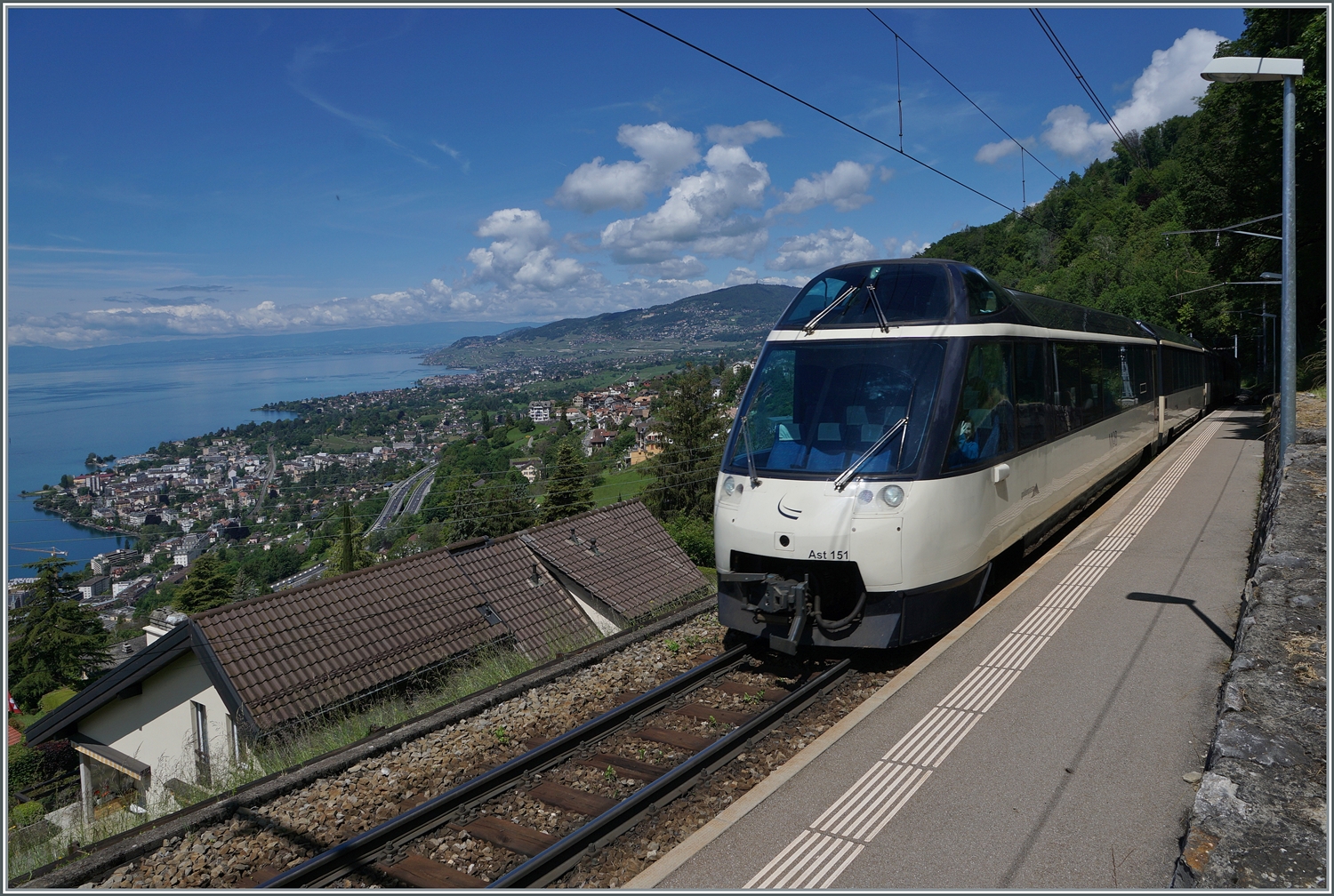 Noch mehr Panorama bietet (dank Weitwinkel) dieses Bild Mit dem Ast 151 an der Spite ist ein MOB Regionalzug von Montreux nach Zweisimmen bei Sonzier unterwegs, während links im Bild der Blick weit über den See, die Riviera Vaudoise und das Lavaux gleitet. 

28. Mai 2024