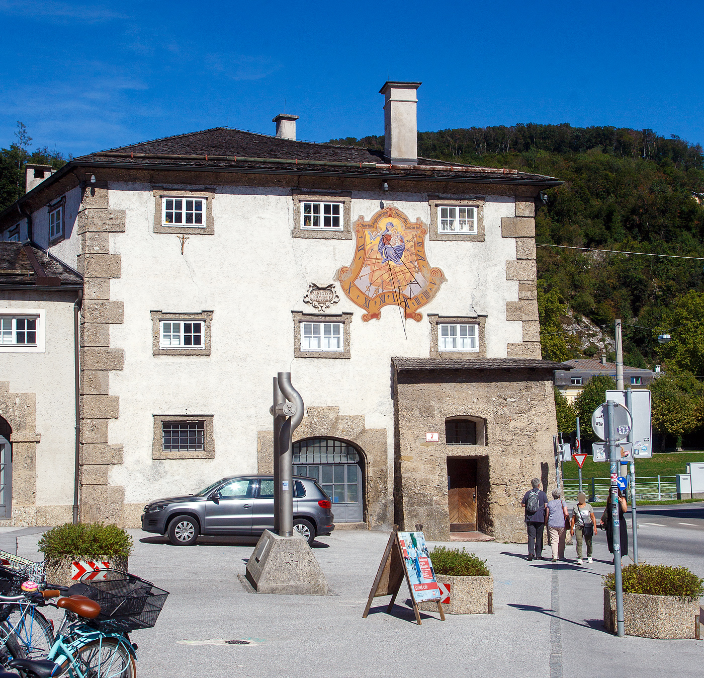 Noch eine sehr genaue Uhr, wenn es nicht die Sommerzeit gäbe....
Die Sonnenuhr am Zeugwartstöckl (Haus Mozartplatz 7) in der Salzburger Altstadt, hier am 12.09.2022.

Die Sonnenuhr wurde 1628 an der südwestlichen Wand des Zeugwartstöckls auf der Seite zum Mozartplatz hin angebracht. Das Zeugwartstöckl ist der noch bestehende Rest des Michaelstors. Schräg links unter der Sonnenuhr befindet sich bis heute eine kleine Inschriftentafel mit Rahmen, die an den Erbauer Fürsterzbischof Paris Lodron im Jahr 1628 erinnert. 

Die Uhr hat sichtbare Zeit-Markierungen in Halbstundenintervallen. Über dem Madonnenbild (Marias mit dem Jesuskind) befindet sich im umlaufenden Band der Gebetsspruch: Steh Uns bey in aller Noth - Hier in löben Und in tod (Steh uns bei in aller Not, hier im Leben und im Tod)
