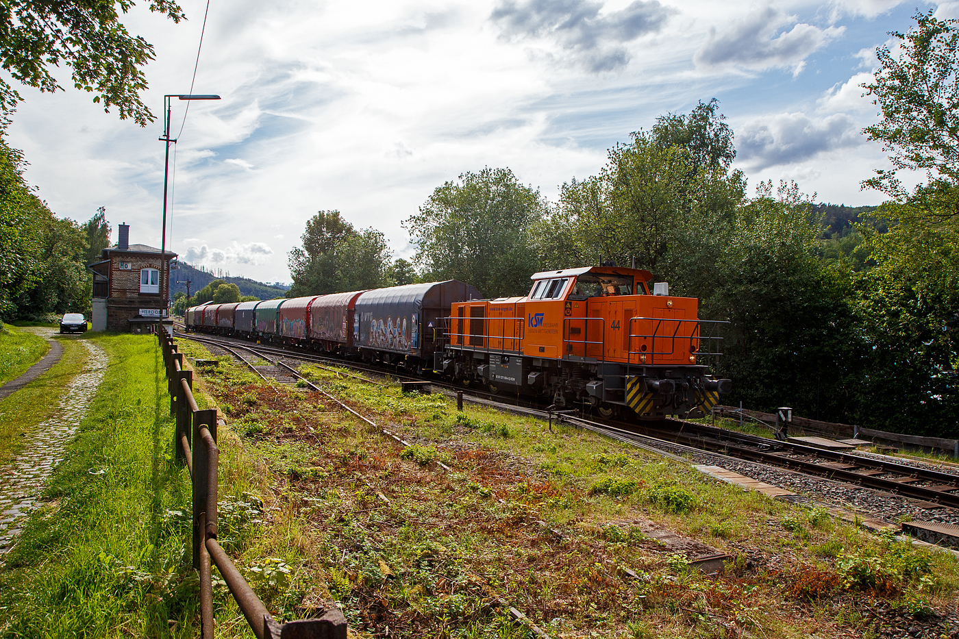 Nun fährt am 12.07.2023 die KSW 44 (92 80 1271 004-4 D-KSW) eine MaK G 1000 BB der KSW (Kreisbahn Siegen-Wittgenstein) mit einem Coilzug vom Bahnhof Herdorf weiter. Von hier geht es gleich auf den KSW Rbf (Betriebsstätte Freien Grunder Eisenbahn - NE 447) und ohne Halt direkt weiter nach Neunkirchen-Salchendorf zum Pfannenberg (ehemals Grube Pfannenberger Einigkeit), wo sich heute die Produktionshallen der EMW Stahl Service GmbH, ein Geschäftsbereich der SCHÄFER WERKE Gruppe befinden. Schon heute werden 300.000 Tonnen Stahl pro Jahr über die Schiene angeliefert, zukünftig sind sogar 600.000 Tonnen geplant.