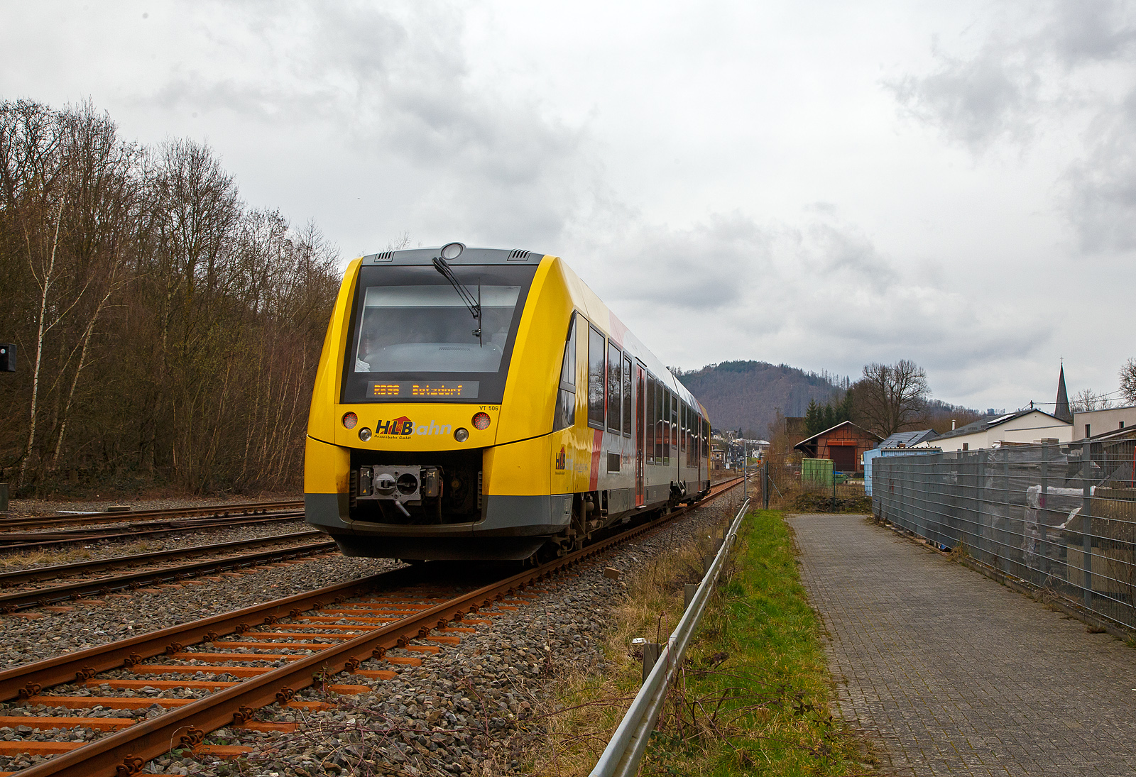 Nun fahren die Triebwagen der HLB RB 96 „Hellertalbahn“ auch endlich wieder den Bahnhof Herdorf an. Leider  ist aber dann in Herdorf am Hp Königstollen Schluss, ab dort gibt es dann von und nach Betzdorf (Sieg) SEV. Nach dem Hangrutsch (Felssturz) am 23. Dezember 2022 in Herdorf kurz hinter dem Hp  Königsstollen (bei km 88,4), ist der Abschnitt nach Betzdorf weiterhin bis mindestens bis zum kleinen Fahrplanwechsel am 11. Juni 2023, gesperrt. Aber diese ungewöhnliche Führung bis zum Hp  Königsstollen, über den Bahnhof Herdorf hinaus ist nötig, denn in den nächsten Tagen sollen die der Abriss und der Neubau der „Hellerbrücke“ der Hellerstraße (bei „Steinaus Eck“) beginnen und der SEV wäre so nur noch über Daaden oder Kirchen möglich.

Hier erreicht der VT 506 (95 80 1648 106-0 D-HEB / 95 80 1648 606-9 D-HEB), ein Alstom Coradia LINT 41 der neuen Generation / neue Kopfform, der HLB (Hessische Landesbahn GmbH) am 20.03.2023, als RB 96 „Hellertalbahn“ nach Betzdorf, bald den Bahnhof Herdorf.