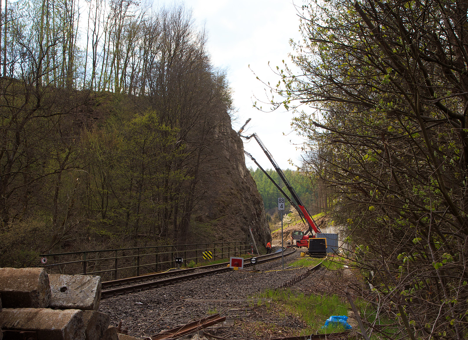 Nun haben die Felssicherungsarbeiten endlich begonnen....
Am 23. Dezember 2022 ca. 18:15 Uhr kam es hier, in Herdorf kurz hinter dem Hp  Knigsstollen (bei km 88,4 der Hellertalbahn KBS 462), zu einem Felssturz und der HLB Triebwagen VT 507, als RB 96 „Hellertalbahn“ entgleiste, verletzt wurde zum Glck niemand. Nun nach ber vier Monaten haben endlich die erforderlichen Sicherungsmanahmen begonnen, hier am 27.04.2023. Zuerst mssen viele 4 m lange Anker in den Fels getrieben werden. Die Arbeiten werden von der Firma FELDHAUS Bergbau GmbH & Co. KG aus Schmallenberg (Hochsauerland) ausgefhrt. 
