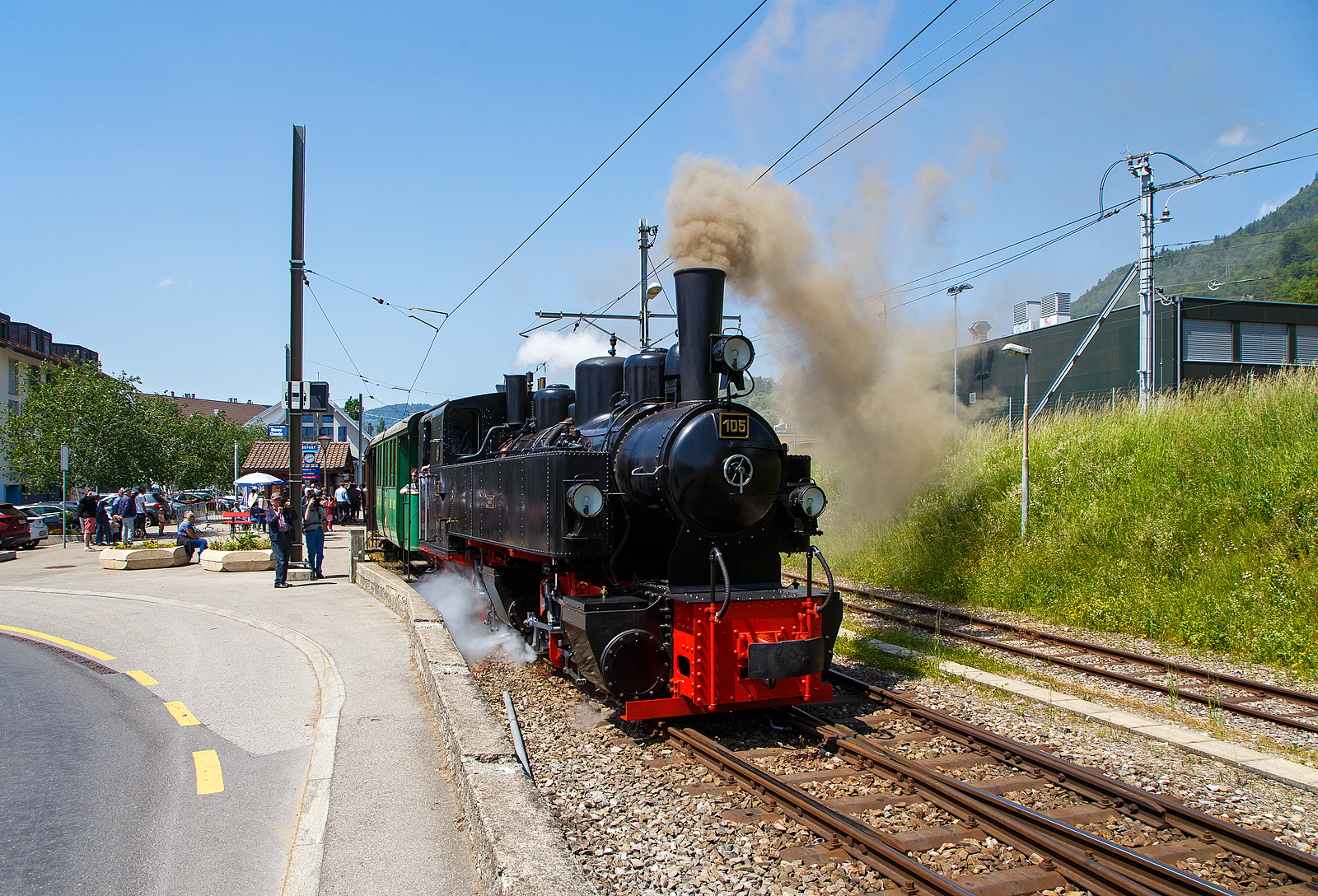 Pfingsten 2023 (Samstag 27. bis Montag 29. Mai 2023) fand bei der Museumsbahn Blonay–Chamby das Schweizer Dampffestival 2023 / Festival suisse de la Vapeur 2023 statt.

Die Mallet-Dampflok G 2x2/2 SEG 105  Todtnau“ fährt am 27.05.2023 mit dem Dampfzug der Museumsbahn Blonay-Chamby von Bahnhof Blonay nun wieder hinauf nach Chamby bzw. zum Museum Chaulin.

Für den Einsatz auf den Meterspur-Strecken in Frankreich bestellten die Deutschen Heeresfeldbahnen bei der Maschinenbau-Gesellschaft Karlsruhe sieben Mallet-Dampflokomotiven. Aus Zeitgründen wurde keine zeitgemäße neue Serie entwickelt. Man nahm alte Konstruktionsunterlagen als Grundlage. Die Auslieferung erfolgte im August 1918. Bevor die Maschinen HK 94 bis HK 100 (HK = Heeresprüfkommission für Feldbahnen) ihren Einsatzort erreichten, war der I. Weltkrieg (Waffenstillstand von Compiegné am 11. November 1918) jedoch schon beendet. Da sie nicht mehr von den Heeresfeldbahnen benötigt und nicht zum Reparationsgut zugeordnet wurden, übernahm sie das Reichsverwaltungsamt. Dieses verkaufte in den Jahren 1919/1920 die Loks.

Die Lok wurde 1918 von der Maschinenbau-Gesellschaft Karlsruhe unter der Fabriknummer 2051gebaut und von der Heeresprüfkommission für Schmalspurbahnen abgenommen als Lok „HK 95“ abgenommen, wegen dem Kriegsende kam sie auf den Heeresfeldbahnen nicht mehr zum Einsatz. So wurde sie 1919 an die Kleinbahn Voerde-Haspe–Breckerfeld als HVB 28 verkauft. Die Kleinbahn Voerde-Haspe–Breckerfeld wurde elektrifiziert, und die  Nr. 28  wurde 1925 an die Zell-Todtnau-Eisenbahn (in der Nähe von Freiburg) der Süddeutsche Eisenbahn-Gesellschaft (SEG) abgegeben, wo sie die  Nummer 105  -  Todtnau  erhielt. Sie blieb bis zur Streckenstillegung der Linie im Jahre 1968 im Schwarzwald und ging gleich drauf an die Museumsbahn Blonay – Champy.
Es ist noch eine Schwesterlok erhalten geblieben, es ist die 99 5906 der HSB.

Konstruktion:
Das hintere Triebwerk mit den Hochdruckzylindern ist fest im Blechrahmen gelagert. Das vordere Triebwerk mit den Niederdruckzylindern ist mit einem Königszapfen mit dem hinteren Triebwerk verbunden, der genietete Kessel liegt mit Gleitplatten auf ihm auf. Seitliche Blattfedern halten das Triebwerk in einer mittigen Stellung. Beide Triebwerke haben einen Innenrahmen.

Der Dampf wird erst zu den hinteren Zylindern geleitet, von dort gelangt er über flexible Leitungen in die vorderen Zylinder. Alle Zylinder verfügen über Flachschieber und außenliegende Heusinger-Steuerung mit Hängeeisen.

Die Loks verfügen über eine Wurfhebel-Handbremse und eine Dampfbremse als Zusatzbremse. Je nach Bahn wurden später Saugluft- oder Druckluftbremse als Zugbremse nachgerüstet.

Auf dem Kessel sitzen zwei Sanddome, einer für jedes Triebwerk.

TECHNISCHE DATEN:
Hersteller Maschinenbau-Gesellschaft Karlsruhe (MBK)
Baujahr: 1918
Betriebsgattung: K 44.9
Kurzbezeichnung: B' B n4vt
Spurweite: 1.000 mm
Kurzbezeichnung: B' B n4vt
Länge über Puffer: 9.400 mm
Höhe über SO: 3.800 mm
Achsstand im Triebwerk: 1.400 mm
Treibraddurchmesser: 1.000 mm
Leergewicht: 28,5 t
Dienstgewicht: 34,4 t
Höchstgeschwindigkeit: 30 km/h
indizierte Leistung: 200 kW (270 PS)
Anfahrzugkraft: 47,76 kN
kleinster befahrbarer Gleisbogen: 50 m
Kesselüberdruck: 12 bar
Kohlevorrat : 1,1 t
Wasservorrat: 3,6 m³
Zylinderanzahl: 4
Zylinderdurchmesser: 280 mm (HD) / 425 mm (ND)
Kolbenhub: 500 mm
Bremse: Knorrbremse m. Z., Wurfhebel-Handbremse

Geschichte der Mallet-Lokomotiven:
Der zunehmende Verkehr auf schmalspurigen Eisenbahnen erschloss Mallet ein anderes Wirkungsfeld. Diese Bahnen benötigten stärkere und damit größere Maschinen, als es die engen Kurven der Schmalspurstrecken zuließen. Die einzige Lösung schienen hier Lokomotiven mit schwenkbaren Fahrwerken zu sein. Dazu waren bereits die Bauarten von Fairlie und Meyer verbreitet, die schwenkbare Maschineneinheiten verwendeten. Die einzelnen Einheiten wurden mit Dampf über flexible Verbindungen gespeist, die sich jedoch stets als Schwachpunkt der Maschinen erwiesen. Mallet entwickelte stattdessen eine Bauart mit zwei Fahrwerken, von denen nur das vordere, unter der Rauchkammer befindliche Fahrwerk schwenkbar gelagert war, während der Kessel fest auf dem anderen Fahrwerk ruhte. Damit reduzierte sich die Zahl der flexiblen Verbindungen um die Hälfte. Der wesentliche Unterschied der Konstruktion von Mallet im Vergleich zu den Bauarten Fairlie und Meyer war aber die perfekte Anwendung eines Verbundtriebwerkes. Der Frischdampf wird zunächst zu den Hochdruckzylindern des fest gelagerten Fahrwerks geleitet und nach dem Auslass in die Niederdruckzylinder des vorderen beweglichen Fahrwerks. Die dorthin führende bewegliche Dampfleitungsverbindung war wegen des geringeren Drucks besser beherrschbar als bei reiner Frischdampf-Versorgung. Diese Bauart ließ Mallet sich 1884 patentieren.

Dampflokomotiven haben im Allgemeinen zwei Arbeitszylinder, die Mallet-Loks besitzen diese Einrichtungen doppelt, also 4 Zylinder mit zugehörigen Triebwerksgruppen. Der Abdampf der ersten ist gleichzeitig der Arbeitsdampf der zweiten Zylindergruppe.
