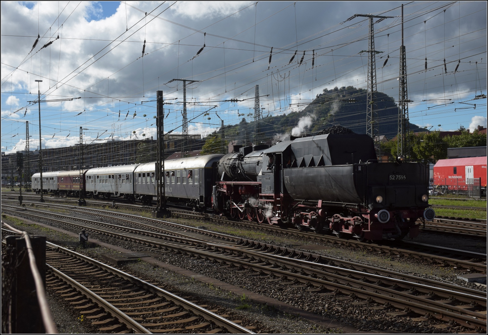 Schienenverkehr unterm Hohentwiel. 

52 7596 mit ihrem EFZ-Sonderzug für die SEHR & RS verlässt den Bahnhof Singen. Oktober 2022.
