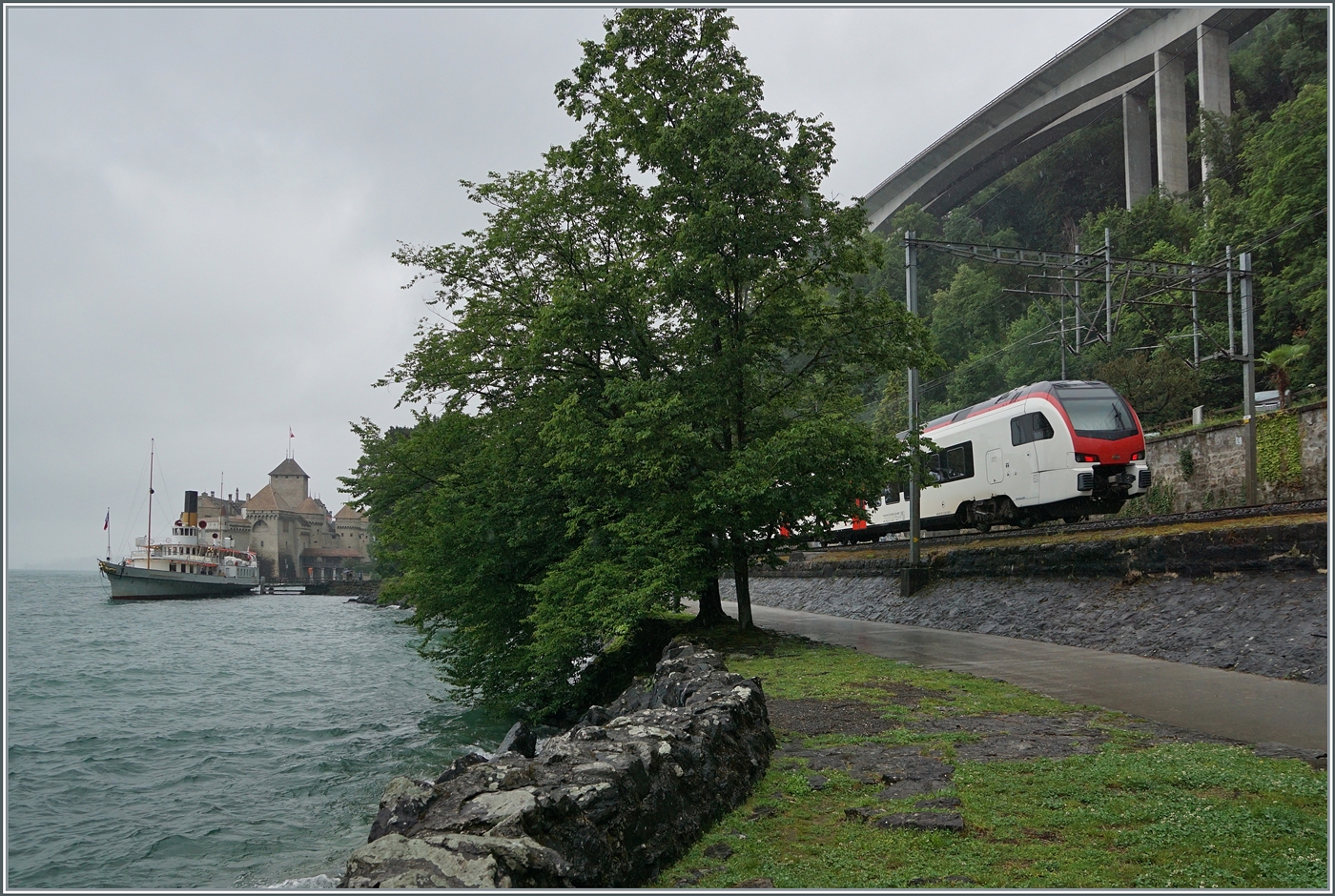 Schiff und Bahn: Während der CGN Schaufelraddampfer  Italie  die Anlegestelle Château de Chillon verlässt, ist ein SBB RABe 523  Mouette  auf der Fahrt nach Lausanne. 

22. Juni 2024