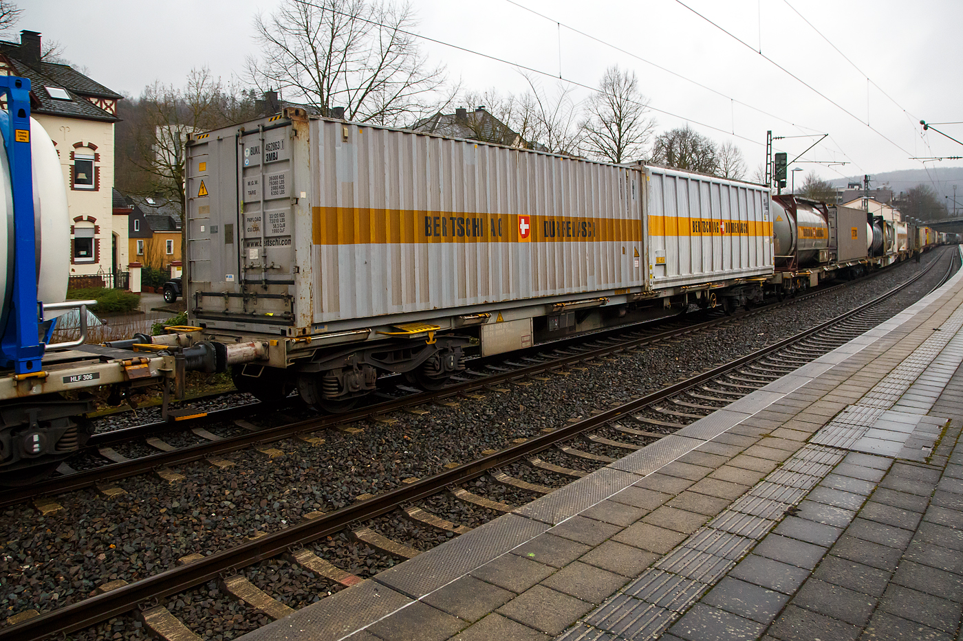 Vierachsiger Drehgestell-Containertragwagen der Gattung Sgnss, 33 85 4575 627-6 CH-HUPAC, der HUPAC Intermodal SA am 31.01.2023 im Zugverband bei der Durchfahrt in Kirchen (Sieg). Hier beladen mit zwei ISO-Containern vom Logistikdienstleister Bertschi AG (Dürrenäsch / Schweiz).

Der Wagen wurde 2003 von Josef Meyer Rheinfelden (CH) gebaut.

TECHNISCHE DATEN:
Hersteller: Josef Meyer Rheinfelden
Spurweite: 1.435 mm
Länge über Puffer: 20.050 mm
Drehzapfenabstand: 14.420 mm
Achsabstand in den Drehgestellen: 1.800 mm
Laufraddurchmesser: 920 mm (neu)
Ladelänge: 18.760 mm
Eigengewicht: 20.000 kg
Max. Zuladung bei Lastgrenze S: 70,0 t (ab Streckenklasse D)
Max. Zuladung bei Lastgrenze SS: 39,0 t (ab Streckenklasse A)
Max. Geschwindigkeit: 100 km/h, bei Lastgrenze SS oder leer 120 km/h
Kleinster befahrbarer Gleisbogen: R 75 m 
Verwendungsfähigkeit: RIV