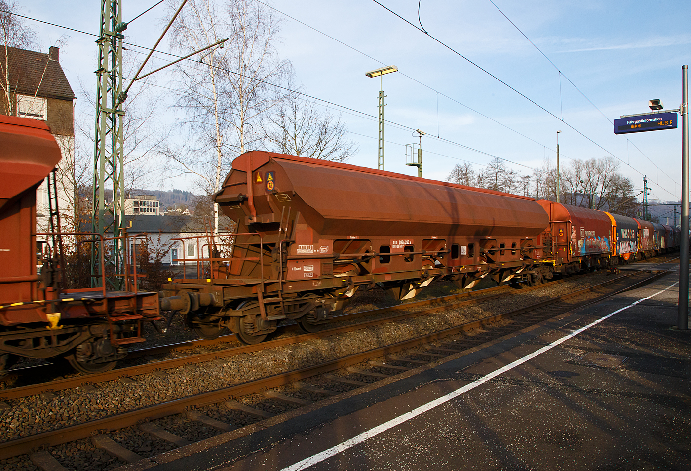 Vierachsiger gedeckter Drehgestell-Schüttgutwagen mit dosierbarer Schwerkraftentladung, 31 80 0834 243-4 D-DB, der Gattung Tads 960, der DB Cargo AG am 18.01.2023 im Zugverband bei einer Zugdurchfahrt in Scheuerfeld (Sieg).

Die Wagen sind geeignet für den Transport von witterungsempfindlichen Schüttgütern. Die Ladegüter sind z.B. Quarzsand, Dolomit, Anthrazit, Gipsstein, Kalk, Holzpellets, Petrolkoks, Kaolin und Paraffine. Die Beladung erfolgt über ein einteiliges Schwenkdach. Sie besitzen eine gleisseitige dosierbare Entladeeinrichtung. Ein Teil der Wagen ist für den Transport von Quarzsand mit speziellen Dichtungen an den Auslaufrutschen ausgestattet.

Die Wagen der Bauart Tads 960 sind durch Umzeichnung aus der Bauart Tads 959 hervorgegangen. Der Wagen dient wegen seiner besonderen Schieberabdichtung dem Transport von feinkörnigen, nässeempfindlichen Schüttgütern, besonders für Quarzsand. Der Transport grobkörniger oder kantiger, schwerer Güter (z. B. Kies, Schlacke, Schotter) ist wegen einer möglichen Beschädigung der Innenbeschichtung nicht zulässig. Der Wagen kann wahlweise nach der einen oder anderen Seite oder gleichzeitig nach beiden Seiten entladen werden. Die regelbare Entladung ermöglicht die Beschickung von Förderbändern. Die schwenkbaren Auslaufrutschen gestatten den Einsatz des Wagens für die Entladung in Bunkern oder auf seitliche Förderbänder.

Das Untergestell ist aus Walzprofilen (St 52-3) geschweißt. Der Wagenkasten ist ebenfalls geschweißt. Für die 3 mm dicken Kastenbleche wurde St 52-3 mit Cu-Zusatz verwendet. In jeder Seitenwand sind vier exzentrisch gelagerte Rundschieber angeordnet. Jeder Schieber kann einzeln mit einem Handhebel von der Bühne aus geöffnet und geschlossen werden.Die Unterkanten der festen Auslaufrutschen liegen bei leerem Wagen 720 mm über SO. Die Unterkanten der beweglichen Auslaufrutschen liegen bei leerem Wagen im ausgeschwenkten Zustand 385 mm über SO.

Zum Beladen des Wagens wird das Schwenkdach von der Bedienungsplattform aus mit einem Handrad geöffnet. Dabei wird eine über die ganze Wagenlänge reichende Öffnung von 1 200 mm Breite freigegeben. Das geöffnete Dach bleibt innerhalb der Wagenbegrenzungslinie, so dass Verschiebebewegungen auch bei geöffnetem Schwenkdach möglich sind.

Das Entfernen von Ladegutresten in der Be- oder Entladestraße ist nur durch leichte Gummihammerschläge auf die äußeren Behälterwandungen gestattet oder durch den Einsatz von Pressluftlanzen im Laderaum.

TECHNISCHE DATEN:
Hersteller: Waggonfabrik Talbot in Aachen
Baujahr: ab 1973 (Umzeichnung 2003 – 2006)
Spurweite: 1.435 mm
Länge über Puffer : 21.640 mm
Drehzapfenabstand: 16.600 mm
Achsabstand im Drehgestell: 1.800 mm
Beladeöffnung: 16.800 x 1.200 mm
Eigengewicht: 24.000 kg
Höchstgeschwindigkeit:  100  km/h (beladen) / 120 km/h (leer)
Maximales Ladegewicht: 56,0 t (Streckenklasse C oder höher)
Kleinster bef. Gleisbogenradius: 75 m
Rauminhalt: 80,0 m³
Bremse: KE-GP-A 
Intern. Verwendungsfähigkeit: RIV

Die Bedeutung der Gattungs- und Kennbuchstaben (hier Tads):
T - Wagen mit öffnungsfähigem Dach 
a - mit vier Radsätzen
d - mit Schwerkraftentladung, dosierbar, wahlweise zweiseitig, hochliegend
s - Höchstgeschwindigkeit 100 km/h (beladen)