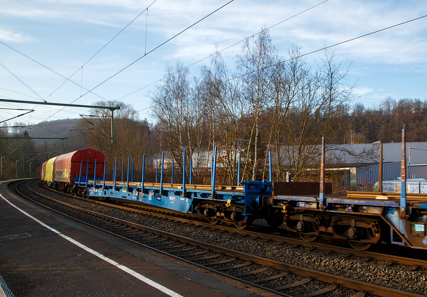 Vierachsiger langer Drehgestell-Flachwagen mit Rungen und Stirnwandklappen, 83 80 3509 014-4 D-TAUAX, der Gattung Rbkks, der irländischen Vermietungsfirma TOUAX Rail Limited, am 18.01.2023 Zugverband bei einer Zugdurchfahrt in Scheuerfeld (Sieg) in Richtung Köln.

TECHNISCHE DATEN (laut Anschriften): 
Spurweite: 1.435 mm
Länge über Puffer:  26.200 mm
Drehzapfenabstand:  21.020 mm
Achsabstand im Drehgestell: 1.800 mm
Länge der Ladefläche: 24.800 mm
Höchstgeschwindigkeit: 100 km/h (beladen) / 120 km/h (leer)
Eigengewicht:  30.200 kg
Maximale Ladegewicht:  59,8 t (ab Streckenklasse D)
Bauart der Bremse: KE-GP (LL)
Bremssohle: IB 116
Kleinster bef. Gleisbogenradius: 75 m
Intern. Verwendungsfähigkeit: Privatwagen ohne RIV

Die Bedeutung der Gattungs- und Kennbuchstaben (hier Rbkks):
R - Drehgestellflachwagen in Regelbauart
b - Ladelänge mindestens 22 m
kk - höchste Lastgrenze 40 t bis unter 60 t (über 60 t wäre es „n“)
s - Höchstgeschwindigkeit 100 km/h (beladen)