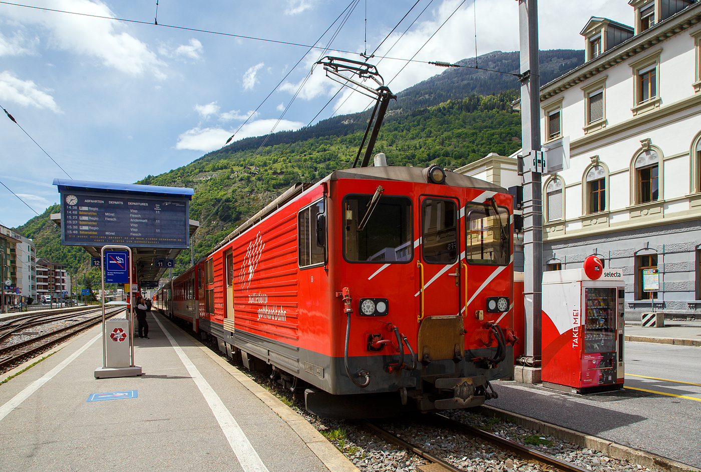 Von dem Gepäcktriebwagen Deh 4/4 II - 96  Münster   der Matterhorn-Gotthard-Bahn (MGB), ex FO 96  Münster   (Furka-Oberalp-Bahn), geschoben erreicht am 25.05.2023 der Regionalzug von Andermatt nach Visp den Bahnhof (Vorplatz) Brig.

Der Gepäcktriebwagen wurde 1984 von SLM (mechanischer Teil, Lokomotivkasten) und BBC (elektrische Ausrüstung) gebaut.