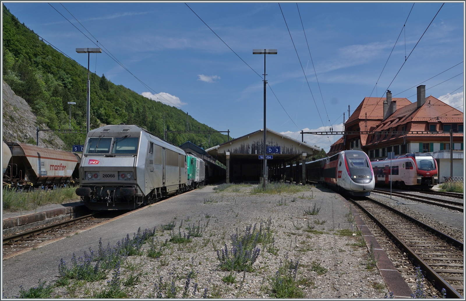 Während rechts im Bild der TGV Lyria 9268 den Bahnhof Vallorbe in Richtung Paris Gare de Lyon verlässt, steht links im Bild der (leere)  Spaghetti -Zug mit der SNCF BB 26068 (91 87 0026 068-3 F-SNCF) und BB 27067 bzw. BB 427067 (UIC 91 87 0027 067-4 F-SNCF) abgebügelt auf Gleis 4. Der Güterzug wird nach der Pause der beiden Lokführer pünktlich Richtung Frankreich abfahren. So viel SNCF ist in Vallorbe leider nicht oft zu sehen. Zudem ist im Hintergrund noch ein SBB Flirt3 zu erkennen. 

16. Juni 2022 