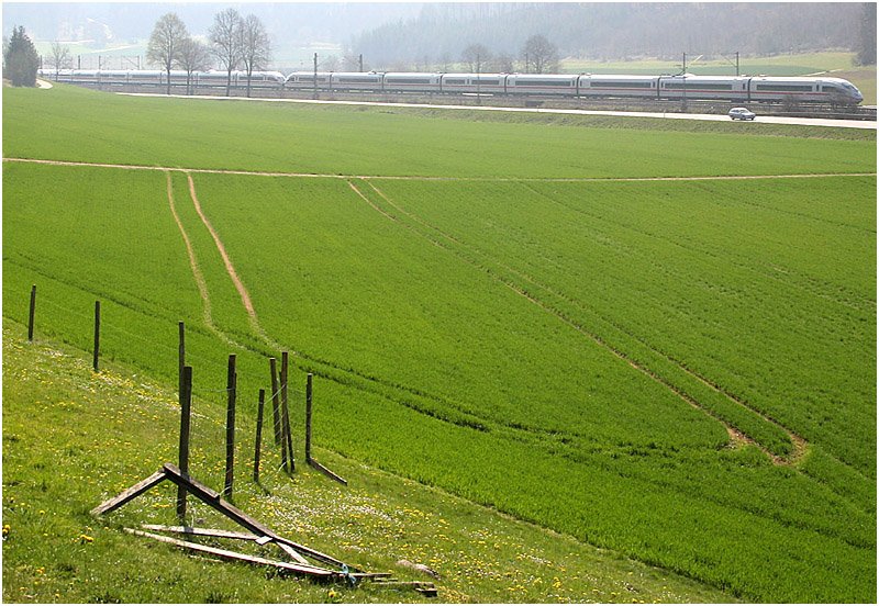 Ein Bahn-/Landschaftsbild, aber in ungew�hnlicher Aufteilung. Unten viel Feld mit den Traktorspuren und oben, eher schon im Hintergrund und im Gegenlicht der ICE-Zug. Die Aufnahme entstand zwischen Amstetten und Ursping an der Strecke Stuttgart - Ulm.