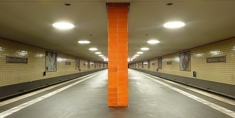 S-Bahnhof Oranienburger Str in Berlin. Der unterirdische Bahnhof wurde von *dem* Bahnhofsarchitekten der S-Bahn R.Brademann entworfen und erinnert an die U-Bahnh�fe Grenanders. Ganz in ornage gehalten nimmt er bezug zum Namen der Station (�hnlich wie Unter den Linden auch passend gr�n gehalten wurde).