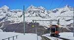 Hinab nach Zermatt fährt am 10.05.2024 ein Bhe 4/6-Doppel der Gornergratbahn, zweites Fahrzeug ist der Beh 4/6 3093, aus der Station Rotenboden, im Hintergrund die Spitzen der drei Viertausender Dent Blanche (4357 m), Obergabelhorn (4073 m) und  ...