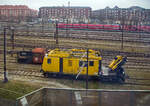 Ein Bild aus dem EC am 20 März 2019 beim Hauptbahnhof Kopenhagen (Københavns Hovedbanegård): Im Vordergrund der Plasser & Theurer Motorturmwagen MTW 10, TR 433 - 99 86 9236 433-9 DK-BDK der Banedanmark (BDK), links dahinter der DSB-Køf-Rangiertraktor Kö ll 263. Im Hintergrund fährt eine S-Bahn bzw. DSB SA 81xx (S-Tog).

Der DSB-Køf-Rangiertraktor:
Der DSB-Køf-Rangiertraktor Kö ll 263 wurde 1966 von der Maschinenfabrik Frichs Maskinfabrik og Kedelsmedie A/S in Aarhus (Århus im Stadtteil Åbyhøj) unter der Fabriknummer 874 gebaut und an die DSB - Danske Statsbaner (Dänische Staatsbahnen) geliefert.

Auf Grund der guten Erfahrungen in Deutschland mit Kleinlokomotiven (Köf) mieteten die Danske Statsbaner im November 1963 die Köf 6645 an, die nach einer Einweisung der DSB-Lokführer, 1964 in Dänemark war. Nach der Erprobung bestellten die DSB 20 Rangiertraktoren, die im Sprachgebrauch in Anlehnung an die deutsche Bezeichnung Køf genannt wurden. Die 251–270 wurden bei Frichs Maskinfabrik og Kedelsmedie A/S in Aarhus (Århus- Åbyhøj) bestellt und 1966 geliefert. Im Gegensatz zur deutschen Baureihe haben die dänischen Køf einen englischen Leyland-Motor. 1967 bestellte die DSB weitere 20 Køf bei Frichs, die 271–290. Die Serie erhielt ein geschlossenes Führerhaus mit Fenstern und Türen und wurde 1968 und 1969 geliefert.

Aufbau:
Das Führerhaus ist auf beiden Seiten mit einem Bedienplatz ausgestattet und mit der niedrigen Fußbodenhöhe von etwa 400 mm über Schienenoberkante dem Ein- und Aussteigen beim Rangieren angepasst. Der Sechszylinder-Viertakt-Motor von Leyland leistet 128 PS (94 kW) bei 1800/min. Sein Kühlwassersystem besitzt eine Vorwärmeinrichtung mit 2.000 W bei 110 V. Der Motor ist über eine Kardanwelle mit dem Voith-Hydraulikgetriebe L33u verbunden. Vom Voith-Getriebe geht die Kraftübertragung über ein Wendegetriebe von Gmeinder und Rollenketten e auf beide Achsen.

Vom Motor, der über ein Handrad bedient wird, werden über Riemen Kompressor und Generator angetrieben. Das Bremsventil für den Zug liegt auf der rechten Führerstandsseite, die Lok allein kann über ein links und rechts vorhandenes Bremsventil gebremst werden.

Die ersten 20 Lokomotiven wurden mit offenen Führerhäusern ohne Türen und Seitenfenster geliefert. Die zweite Serie wurde mit einem vollständig geschlossenen Führerhaus geliefert, ab 1968 erfolgte die Nachrüstung der ersten Serie.

Ursprünglich waren alle Fahrzeuge an beiden Enden mit einer automatischen Rangierkupplung ausgerüstet, die beim Anfahren an einen Wagen automatisch kuppelte und vom Führerstand durch Druckluft entkuppelt werden konnte. Für Zugfahrten wurde sie hochgeklappt und die Schraubenkupplung des ersten Wagens mit dem Kupplungshaken der Lok verbunden. Einzelne Lokomotiven erhielten später normale Schraubenkupplungen.

Ursprünglich waren alle Køfs grün, einige erhielten später das rot/schwarze DSB-Farbschema. Bei einigen Maschinen wurde die Betriebsnummer in übergroßen Ziffern zusätzlich auf dem Dach des Führerhauses als sogenannte  Flyvernummer  (Fliegernummer) angebracht, um sie von den Stellwerken aus leichter identifizieren zu können. Ab 1988 verbesserten eine geräuschdämmende Auskleidung des Führerhauses sowie eine kühlwasserbetriebene Heizung die Arbeitsverhältnisse auf den Loks.

Der Einsatz der Køfs erfolgte landesweit im Rangierbetrieb, vereinzelt übernahmen sie auch leichte Güterzüge im Streckendienst. Mit der Übernahme der Gütersparte  DSB Gods  durch  Railion DK  (heute DB Cargo Scandinavia) gelangten 2001 insgesamt 26 Køfs zum neuen Betreiber, 13 verblieben bei der DSB. Die Railion-Køfs wurden unverändert weiter betrieben und lediglich durch aufgeklebte Schriftzüge gekennzeichnet. Aus dem Überbestand endeten einige Köfs als Ersatzteilspender, andere wurden von verschiedenen Privatbahnen und Gleisbauunternehmen erworben, 5 weitere Køfs blieben museal erhalten. Die veräußerten Køfs wurden bei den neuen Betreibern in Stand gesetzt und erstrahlten in einem bunten Strauß neuer Farbschemata.

Zur Verlängerung der Lebensdauer setzte die DSB 2020 in der Werkstatt Fredericia Køf 253, 263, 273 und 290 instand (die zusätzlich beabsichtigte Moderisierung von Køf 270 wurde nicht ausgeführt). Motor, Getriebe und Bremsanlage wurden überholt, die elektrischen Leitungen wurden erneuert und alle Luftkomponenten erhielten eine Revision bei der  Westfälische Lokomotiv-Fabrik Reuschling  in Hattingen. Auch die Scheinwerfer wurden erneuert, wobei Leuchten mit integrierten roten LED-Ringen aus den zeitgleich verschrotteten MR-Triebzügen verwendet wurden. Bei der Neulackierung mit schwarzem Rahmen und grünen Aufbauten wählte das Werkstattteam einen vergleichsweise hellen Grünton, angelehnt an das  British Racing Green . Die Innenräume der Führerstände blieben ohne Renovierung. Insgesamt überschritt das Projekt die bewilligten Ressourcen an Arbeitszeit und Budget deutlich. Weitere Køf-Instandsetzungen wurden ausgeschlossen, da die Werkstatt in Fredericia geschlossen wurde und das beteiligte Personal in Rente ging.

Anfang 2024 kündigte DB Cargo Scandinavia an, ebenfalls 5 ihrer Køfs instandsetzen zu wollen.

TECHNISCHE DATEN:
Anzahl: 40
Hersteller: Frichs in Aarhus
Baujahre: 1966, 1968-1969
Spurweite:  1.435 mm (Normalspur)
Achsfolge:  B
Länge über Puffer: 6.400 mm
Höhe: 2.935 mm
Breite: 3.070 mm
Achsstand : 2.500 mm
Treibraddurchmesser: 850 mm (neu)
Motor: Leyland UE 680, 6-Zylinder –Viertakt-Dieselmotor
Leistung: 94 kW (128 PS) bei 1.800 U/min
Getriebe: Voith L33u
Kraftübertragung: Dieselhydraulisch, d.h. vom Motor über Gelenkwelle auf Voith-Getriebe über ein Wendegetriebe von Gmeinder über Rollenketten auf beide Achsen.
Höchstgeschwindigkeit: 45 km/h
Dienstgewicht: 17,0 t
Tankinhalt: 200 l
