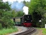99 4011-5 warnt alle Verkehrsteilnehmer mit einem langen Pfiff.Hier kommt sie langsam mit P 105 in Binz eingefahren am 02.08.2014