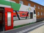 Blick auf einen Triebzug der Baureihe 650 in dessen Fenster sich ein DR-Doppelstockwagen spiegelt.