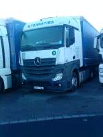 SZM Mercedes-Benz Actros 1842 mit Pritsche-Planen-Auflieger der Spedition Transtira auf dem Autohof in Grnstadt am 30.12.2013