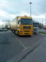 SZM MAN TGX 18.440 mit Pritsche-Planen-Auflieger der DHL auf dem Parkplatz an der Raststtte Schifferstadt am 06.01.2014