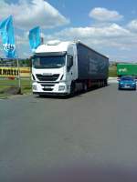 SZM IVECO Stralis mit Pritsche-Planen-Auflieger der Spedition Jung gesehen auf dem Autohof in Grnstadt am 16.05.2014