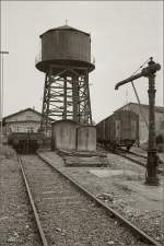 Bahnanlagen des Bahnhof Konstanz. Hinter Wasserkran und Wasserturm steht der Güterschuppen der SBB, Warenausgabe für Stückgut. 1971.