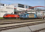 Ein besonderer Gast lässt den Bahnhof im Nachbarland vermuten. Re 465 008-1 der BLS wartet in Konstanz auf Abfahrt nach Romanshorn, während sich nebenan Re 460 103-5 der SBB mit einem IR auf den Weg nach Zürich macht. März 2016.