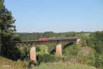 185 084 überquert bei Beratzhausen das Viadukt mit einem Kesselzug.