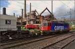 Werksverkehr fernab der Schweiz. Re 4/4 II 11390 transportiert zwei Torpedopfannenwagen mit Flüssigeisen von der Eisenhütte in Völklingen nach Dillingen. Im Hintergrund die riesige, historische Völklinger Hütte, heute Unesco Weltkulturerbe. Juli 2014