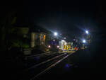 Die Baustelle Bahnhof Herdorf am Abend (19:15 Uhr) des 26 Oktober 2025, nach der Zeitumstellung ist es nun um diese Zeit wieder stockdunkel. Die Gleisbauer der KAF Falkenhahn Bau AG (Kreuztal) waren schon gegen 16 Uhr, noch bei Tageslicht, fertig mit dem Einschottern und mussten dann auf die Stopf- sowie die Schotterplaniermaschine warten. Nun sind beide angekommen. Ich hatte hier vom Bahnsteig im Bahnhof die Ankunft festgehalten und da ich schon öfter das Stopfen gesehen und dokumentiert habe, so ging es wieder nach Hause. 

Zu Hause angekommen habe ich die Bilder auf den PC geladen und diese bearbeitet, als ich dann sah, was ich fotografiert hatte, was ich Vorort nicht sehen konnte, so musste ich trotz der Dunkelheit nochmals zur Baustelle. Aber ich wählte dann, auf der anderen Seite beim Stellwerk Herdorf Fahrdienstleiter in der August-Sander-Straße aus. Übrigens die Straße ist nach dem 1876 in Herdorf geboren bekannten deutschen Fotograf August Sander benannt. Dieser Fotostandort war weitaus besser und näher am Geschehen, als hier vom Bahnhof.  
