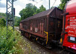 Vierachsiger Drehgestell-Flachwagen mit verschiebbaren Teleskophauben für Coiltransporte, 31 80 4671 011-3 D-DB, der Gattung Shimmns-u 708, der DB Cargo AG, am 16 Juli 2025 im Zugverband (Zug 9921) bei der Zugdurchfahrt in Kirchen (Sieg) in Richtung Siegen bzw. Ziel Kreuztal. 

Der Wagen eignet sich speziell für den Transport witterungsempfindlicher Blechrollen. Er besitzt feste Stirnwände, 5 fest im Untergestell eingebaute Lademulden und drei teleskopartig angeordnete Hauben, die sich zu beiden Wagenenden hin soweit durch Ineinanderschieben öffnen lassen, dass jeweils 2/3 des Wagens freigelegt werden kann. Hierdurch ist eine einfache Beladung des Wagens sowohl von oben als auch von der Seite aus möglich. Der Wagen darf nur mit geschlossenen und verriegelten Hauben verkehren.

Das Untergestell und die festen Stirnwände, die als Abkantrahmenkonstruktion mit Blechbekleidung und hutförmigen Verstärkungsprofilen ausgeführt sind, sowie die fest auf den Außenlangträgern angeordneten drei Laufschienen je Wagenseite bilden den als Schweißkonstruktion ausgeführten Wagenkasten. Das Untergestell mit seinen beiden kräftigen Außenlangträgern besteht aus Walz- und Abkantprofilen. Die Untergestellenden bestehen aus den Hauptquerträgern, den AK-Trägern und den Kopfstücken. Die sattelförmig angeordneten, jeweils mit den Außenlangträgern verschweißten Querträger bilden zusammen mit 6 mm dicken Muldenblechen die Lademulden.

Die teleskopartig ineinander verschiebbaren Stahlhauben bestehen aus einer Hohlprofil-Rahmenkonstruktion und einer mit Sicken versehenen Beblechung. Die Abdichtung der Hauben untereinander und zu den Stirnwänden hin erfolgt über labyrinthartig ausgeführten Umrandungsprofilen. Die Endhauben verriegeln in geschlossener Stellung automatisch. Das Entriegeln der Hauben ist sowohl vom Erdboden wie auch von der Rampe möglich. Die beidseitig an jeder Stirnwand angeordneten Verriegelungseinrichtungen sind durch Wellen miteinander verbunden. Hierdurch ist das Entriegeln von nur einer Wagenseite aus möglich. Jede Haube läuft auf 4 jeweils und mit Abhebesicherungen versehenen Laufwagen mit nadelgelagerten Doppelrollen.

Die Wagen der Bauart Shimmns 708 sind mit 12 verstellbaren Festlegearmen ausgerüstet, die in fest auf den Muldenkappen angeordneten kammartig ausgeführten Halterungen gelagert sind. Die Festlegearme und ihre Anordnung ergeben einen wirksamen Schutz gegen unzulässiges seitliches Verschieben der Coils.

Um unzulässige Radlastabweichungen auszuschließen, ist eine möglichst mittige Verladung der Coils erforderlich. Ein durch alle Mulden in Wagenmitte verlaufender weißer Farbstreifen dient hierzu als Orientierungshilfe.

TECHNISCHE DATEN:
Hersteller: LHB - Linke-Hofmann-Busch GmbH in Salzgitter-Watenstedt
Baujahr: 1972, Fabriknummer 407
Spurweite: 1.435 mm (Normalspur)
Achsanzahl: 4 (in 2 Drehgestelle)
Länge über Puffer: 12.040 mm
Länge der Ladefläche: 10.800 mm
Ladebreite (Mulden): 2.400 mm
Drehzapfenabstand: 7.000 mm
Achsabstand im Drehgestell: 1.800 mm
Laufraddurchmesser: 920 mm (neu)
Eigengewicht: 22.800 kg
Höchstgeschwindigkeit: 100 km/h (beladen) / 120 km/h (leer)
Maximales Ladegewicht: 67,0 t (ab Streckenklasse D4) / 61,0 t bei DB ab CM3
Hier betrug das Ladegewicht laut Laufzettel 65.055 kg
Kleinster bef. Gleisbogenradius: 35 m
Bauart der Bremse: KE-GP (LL)
Bremssohle: IB 116
Handbremse: Ja
Intern. Verwendungsfähigkeit: RIV