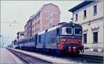 Die FS D 345 1065 erreicht mit ihrem Regionalzug von Novara ihre Ziel Domodossola. Die ersten zwei Wagen tragen die Sammelbezeichnung  Centoporte ,  was auf Deutsch  Hundertt�renwagen  bedeutet. Von 1930 bis Mitte der 1980 waren etwa 2000 Wagen in verschiedene Ausf�hrungen im Einsatz. Da dieses Bild 1985 entstand, waren d�rfte es sich bereits im eine der letzten Eins�tze dieser Wagen gehandelt haben. 

Analogbild vom Mai 1985