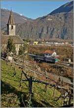 Bei der Kirche von San Quirico kommt der mit ALn 663 Dieseltriebwagen geführte Trenitalia Regionalzug 10381 zum Vorschein.