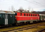 Die 1141.20 (91 81 1141 020-6 A-GEG) der GEG - sterreichische Gesellschaft fr Eisenbahngeschichte GmbH, ex BB 1141 020-6, ex BB 1141.20, ist am 14 Januar 2025 beim Bahnhof Timelkam abgestellt. Bild leider nur aus einem Zug, htten wir gewusst was hier alles herumsteht, dann htten wir einen Stopp eingelegt.

Die vierachsige elektrische Universallokomotive 1957 von der Simmering-Graz-Pauker AG (SGP) in Graz, unter der Fabriknummer 56361, gebaut, bei dieser Lok ist die elektrische Ausrstung von AEG-Union. Als BB 1141.21 wurde sie an die sterreichische Bundesbahnen geliefert. 1986 fhrten auch die BB EDV-gerechte Triebfahrzeugnummern ein. Aufgrund des zukunftssicheren Bezeichnungssystems waren die nderungen berschaubar. Die Ordnungsnummern wurden mit einer vorgesetzten Null dreistellig, der Punkt zwischen Stamm- und Ordnungsnummer entfiel und die Selbstkontrollziffern wurden ergnzt, so wurde aus dieser die BB 1141 021-4 als diese fuhr sie bis zu ihrer Ausmusterung im Jahr 2003 und wurde dann zum 01. Dezember 2003 an die GEG verkauft..

Die Lokomotiven der Reihe 1141 der sterreichischen Bundesbahnen (BB) waren vierachsige elektrische Universallokomotiven die von 1955 bis 2003 im Einsatz waren. Die Maschinen wurden von Simmering-Graz-Pauker gebaut und stellen eine Weiterentwicklung der Reihe 1041 dar.

Die sterreichischen Bundesbahnen bentigten nach dem Zweiten Weltkrieg neue Elektrolokomotiven fr ihr umfangreiches Elektrifizierungsprogramm, womit die Dampftraktion abgelst werden sollte. Da die Instandsetzung der wichtigsten sterreichischen Bahnstrecken rasch voranschritt, wurden ebenfalls neue Lokomotiven bentigt. Der Bedarf wurde vorerst mit den Neubaulok-Reihen 1040 und 1041 gedeckt. Da sich die Loks der Reihe 1041 auerordentlich gut bewhrt hatten, entschieden sich die BB fr eine Weiterentwicklung, die als Reihe 1141 bezeichnet wurde. Als Mindestanforderungen legten die BB eine Hchstgeschwindigkeit von 110 km/h, eine Dienstgewicht von maximal 80 t und eine Leistung von 3.000 kW fest; die Vorgngerreihe wies lediglich eine Hchstgeschwindigkeit von 90 km/h auf, weshalb sie bald vom Einsatz auf den Hauptstrecken verdrngt wurde. 

Zwischen 1955 und 1958 wurden 30 Maschinen an die BB geliefert. SGP in Graz war fr den mechanischen Teil zustndig, der elektrische Teil wurde von den Firmen AEG-Union, BBC, ELIN und SSW hergestellt. Alle Lokomotiven waren bei ihrer Ablieferung Tannengrn lackiert, der Rahmen und das Laufwerk waren schwarz lackiert. Nach einigen Dienstjahren erhielten die 1141er ein blutoranges Farbkleid, einige erhielten spter noch eine verkehrsrote Lackierung, auch wurden teilweise die Fhrerstandstren verblecht und nach hinten in den Maschinenraum versetzt.

Die Loks der Reihe 1141 wurden nach ihrer Ablieferung auf der Westbahn und auf der Sdbahn im Schnellzugverkehr eingesetzt. Sie wurden allerdings im Laufe der Zeit von der Reihe 1042 verdrngt. Zuletzt waren die 1141 in Attnang-Puchheim stationiert. Im Jahr 2003 schieden alle Lokomotiven dieser Reihe aus dem Bestand der BB aus. Die letzten Vertreterinnen waren 1141 007, 020, 021, 022, 024 und 028. 

Mechanische Konstruktion:
Der Wagenkasten entsprach im Groen und Ganzen der Vorgnger-Reihe 1041. Um die Lok so leicht wie mglich zu konstruieren (die von den BB gesetzte 80 t-Grenze durfte nicht berschritten werden), wurden die Drehgestellrahmen in Holmenbauweise ausgefhrt, zudem wiesen die Drehgestelle eine verbesserte Kurvenlufigkeit auf. Die Zugkraftbertragung erfolgte auf gleiche Weise wie bei der Reihe 1041. Der aus Stahlblechen geschweite Kasten sttzte sich auf Gleitbacken am Wiegebalkenende ab. Zwischen den beiden Fhrerstnden lagen der Maschinenraum und ein Verbindungsgang, der Transformator befand sich in der Mitte der Lok. Bei den Lokomotiven der Baureihe 1141 wurde erstmals der heute bekannte und bewhrte Siemens-Gummiringfederantrieb (ein Hohlwellenantrieb) eingebaut. Bevor die Reihe 1141 beschafft wurde, war dieser Antrieb nur probeweise in Bestandsloks verbaut. Die Reihe 1141 ist daher die erste in Serie gebaute Elektrolokreihe mit diesem Antrieb. Im Motorraum waren smtliche Hilfsaggregate und sonstige Gerte untergebracht. Einige Lokomotiven erhielten im Zuge von Ausbesserungsarbeiten einen vernderten Kasten.

Elektrische Konstruktion:
Das Dach trug zwei Scherenstromabnehmer mit Doppelwippe (Bauart V), den Hauptschalter und smtliche Dachleitungen. Unter dem Hauptschalter befand sich der fremdbelftete und lgekhlte Transformator, der im Vergleich zur Reihe 1041 leicht verndert wurde, die Steuerung wurde hingegen beibehalten. Die Loks verfgten ber vier Motoren, das bersetzungsverhltnis des Getriebes betrug 23:88. Alle Lokomotiven verfgten ber eine automatisch wirkende Druckluftbremse, ein Nachbremsventil und eine direkt wirkende Zusatzbremse. Auf die Ausrstung der Maschinen mit einer E-Bremse wie bei der Vorgnger-Reihe musste aus Gewichtsgrnden verzichtet werden.

TECHNISCHE DATEN:
Gebaute Anzahl: 30
Spurweite: 1.435 mm (Normalspur)
Achsformel: Bo’Bo’ (2 Drehgestelle mit je 2 Motoren)
Lnge ber Puffer: 15. 260 mm
Drehzapfenabstand: 7.500 mm
Achsabstand im Drehgestell: 3.200 mm
Treibraddurchmesser: 1.350 mm (neu)
Dienstgewicht: 83,0 t
Stundenleistung bei 77 km/h: 2.480 kW
Dauerleistung: 2.160 kW
Stundenzugkraft: 116 kN
Anfahrzugkraft: 210 kN
Hchstgeschwindigkeit: 110 km/h
Anzahl der Motoren: 4 
Motorenart: 10-polige fremdbelftete Fahrmotoren (je 620 kW Stundenleistung)
Antrieb: Siemens-Gummiringfederantrieb
bersetzung: 1: 3,83
Stromsystem: 15 kV/16,7 Hz