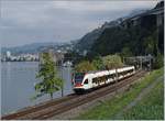 Ein SBB RABe 523 hat Villeneuve verlasen und fährt nun vor dem Hintergrund des Château de Chillon Richtung Lausanne.