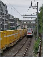 Während ein Postzug in Richtung Lausanne fährt und das Bild mit gelber Farbe schmückt, erreicht ein Flirt auf der Fahrt nach Villeneuve Montreux.