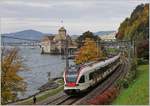 Der SBB RABe 523 013 auf der Fahrt nach Villeneuve beim Château de Chillon, weit im Hintergrund auf dem See ist noch ein CGN Dampfschiff zu erkennen.