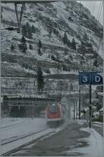 Ein ICN verschwindet schneeaufwirbelnd im Gotthardtunnel.