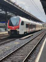 Der SBB Flirt RABe 523 103 in Lausanne auf Gleis 2 vor dem Hintergrund einen Gewitterhaften Abendhimmels  himmels.