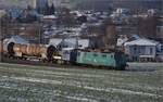 Re 430 114 von WRS mit Synopsis-Werbung schleppt die Rangierhilfe Tm III 9530 mit über den Bözberg.