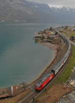 Den zwischen Tiefenwinkel und Mühlehorn einspurigen Streckenabschnitt entlang des Walensees befährt am 16.03.2014 die Re 460 mit ihrem 15 Wagen langen EC 206 auf der Fahrt von Chur nach