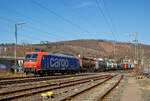 Die Re 482 014-8 (91 85 4482 014-8 CH-SBBC) der SBB Cargo AG fährt am 24.03.2021, mit einem HUPAC-KLV/Container-Zug durch Niederschelden in Richtung Köln.

Die TRAXX F140 AC1 wurde 2002 von Bombardier in Kassel unter der Fabriknummer 33539 gebaut und an die SBB Cargo AG geliefert. Sie hat die Zulassungen und Zugbeeinflussungssysteme für die Schweiz und Deutschland. Zurzeit ist sie an die SBB Cargo International AG vermietet.

Obwohl die Baureihe Re 482 der SBB Cargo grundsätzlich von der Baureihe 185 abgeleitet ist, gibt es doch kleine Unterschiede. Wie bei der deutschen Baureihe 185 handelt es sich bei der Re 482 um eine Zweisystemlokomotive für 15 kV, 16 2/3 Hz und 25 kV, 50 Hz. Zugelassen sind die Lokomotiven für das deutsche und Schweizer Bahnnetz. Im Gegensatz zu den Loks der Baureihe 185, die ab Werk erst ab etwa 185 050 mit einer Leistung von 5.600 kW ausgeliefert wurden, kamen die Loks der Bauart Re 482 bereits mit der erhöhten Leistung zur SBB Cargo.

Weiterhin verfügen alle Re 482 über vier Stromabnehmer, von denen jeweils zwei für die deutsche und zwei für die schweizerische Oberleitung ausgelegt sind. Im Bereich der Sicherungstechnik verfügen die Loks über die deutschen Systeme Indusi, LZB 80 und PZB 90 und die Schweizer Systeme Signum und ZUB 262. Zusätzlich sind im Lokkasten Kameras eingebaut, die Rückspiegel ersetzen sollen. 
Jedoch wurden die Loks 482 010 bis 482 014 (wie diese hier) ohne  Schweizpaket  ausgeliefert und waren erst nur für Deutschland zugelassen. Bei diesen Loks fehlten die Stromabnehmer mit Schweizer Schleifstück, das Sicherungssystem Integra und die bereits erwähnten Kameras. Diese fünf Loks wurden aber alle Ende 2003 auf das  Schweizpaket  umgebaut.

Mit der zweiten Bauserie der Re 482, die ab 482 035 gab es einige Veränderungen an der Lok. Zudem sind diese nun TRAXX F140 AC2. Der gesamte Lokkasten wurde neu gestaltet und auf sein Crashverhalten optimiert. Ebenso erhielten die Fahrzeuge nun neue Puffer, die wiederum mit dämpfenden Elementen verschraubt sind.

Auf Anhieb sichtbar sind die Unterschiede zwischen der ersten und der zweiten Baureihe: Bei der zweiten Bauserie (TRAXX F140 AC2) ist der Übergang zwischen der Dach- und der Stirnfläche wesentlich stärker geknickt als vorher. Weiterhin sind die bisher auf verschiedenen Ebenen angebrachten Griffstangen an der Lokfront bei der zweiten Baureihe nun auf gleiche Höhe direkt unter die Führerstandsfenster gerückt. Unter den Stirnfenstern befindet sich nun eine Klappe, in der die Klimageräte für den Führerstand untergebracht sind. Zudem verfügen einige Re 482 der zweiten Serie (TRAXX F140 AC2) teilweise über Zulassungen für Österreich. 

TECHNISCHE DATEN:
Spurweite: 1.435 mm (Normalspur)
Achsfolge: Bo'Bo'
Dienstgewicht: 85 t
Länge über Puffer: 18.900 mm
Drehzapfenabstand: 10.440 mm
Dauerleistung: 5.600 kW
Höchstgeschwindigkeit: 140 km/h
Fahrleitungsspannung:15000 V, 16.7 Hz ~
Zulassungen: CH / D (Zweite Serie teilweise auch A)