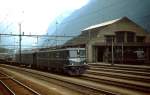 Mit einem Autoshuttle durchfährt Ae 6/6 11403 im Juli 1983 den Bahnhof Erstfeld.