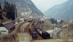 Blick vom Nordportal des (muss man jetzt sagen: alten) Gotthardtunnels auf den Bahnhof Göschenen im Mai 1980: Während die Ae 6/6 mit ihrem Güterzug schon auf dem Weg nach Süden ist, muss die Ae 3/5 mit ihrem Autozug noch ein wenig warten. Nach der Eröffnung des Basistunnels wird es hier bald wesentlich ruhiger sein. Nicht nur vor dieser ingenieurtechnischen Meisterleistung muss man den Hut ziehen, denn außerdem wurde der neue Tunnel überpünktlich fertig und der Kostenrahmen eingehalten. Bei uns ist man anderes gewohnt, da stürzt ein U-Bahn-Tunnel ein, die Eröffnung eines Flughafens wird immer wieder verschoben und immer wieder explodieren die Kosten bei Großbauvorhaben...