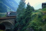 Kurz vor dem Pfaffensprung-Kehrtunnel fährt eine Re 6/6 im Juli 1983 die Gotthard-Nordrampe hinunter