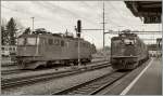 Während die grüne Ae 6/6 11444 in Langenthal auf neue Aufgaben wartet, fährt die rote Ae 6/6 11464 mit ihrer Güterzug ohne Halt durch.