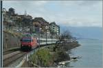 Die SBB Re 460 073-0 am wenig frühlingshaften Genfersee bei St-Saphorin.